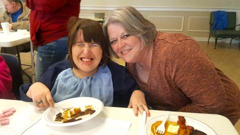 two people smiling at the lunch table